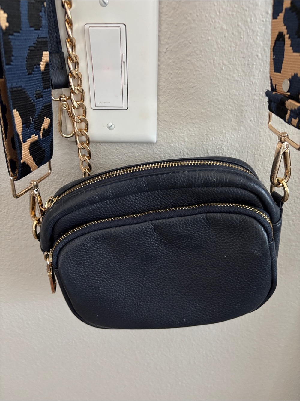 Navy blue Crossbody Bag with Gold Hardware and Patterned Strap. Pom Pom London